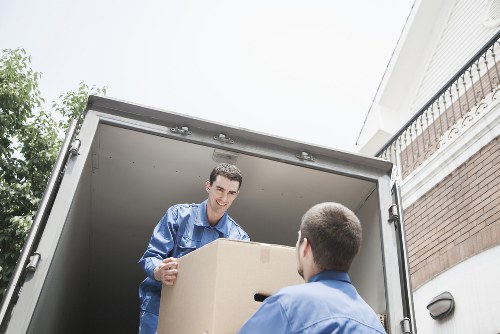 Professional movers transporting furniture through a West Hampstead property